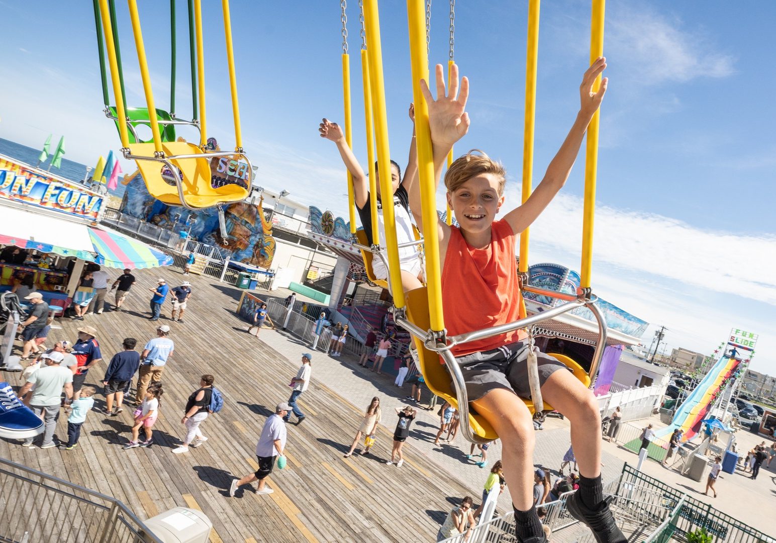 Riders enjoy Wave Swinger ride at Jenkinson's Boardwalk. Visitors pass through boardwalk